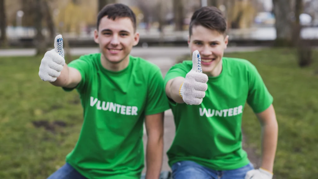 volunteers with their thumbs up towards the camera